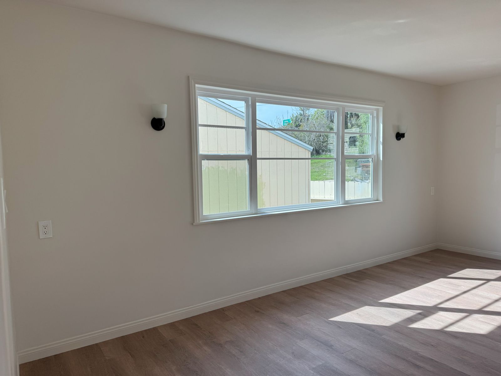 Bright living room with wood-look floors and a large window