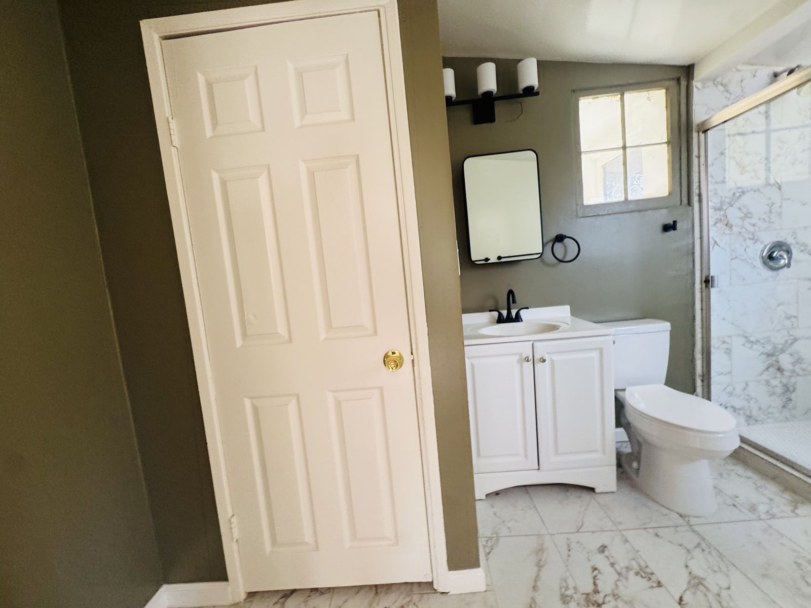 Bathroom with marble-look tile and glass shower