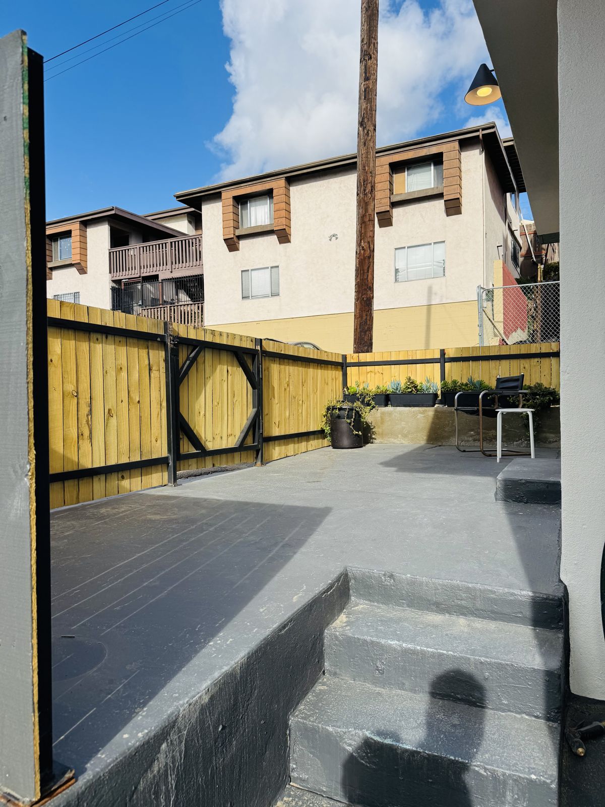 Fenced side patio with steps