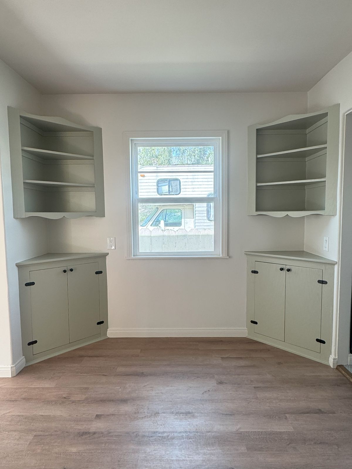 Dining nook with sage-green built-in corner cabinets
