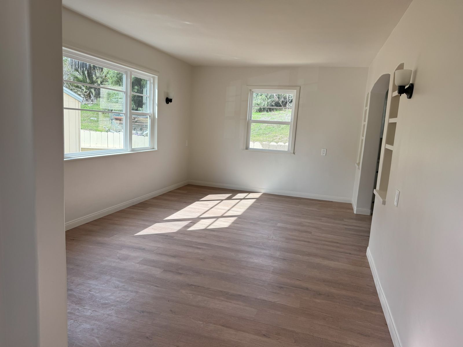 Living room with arched doorway and built-in shelves
