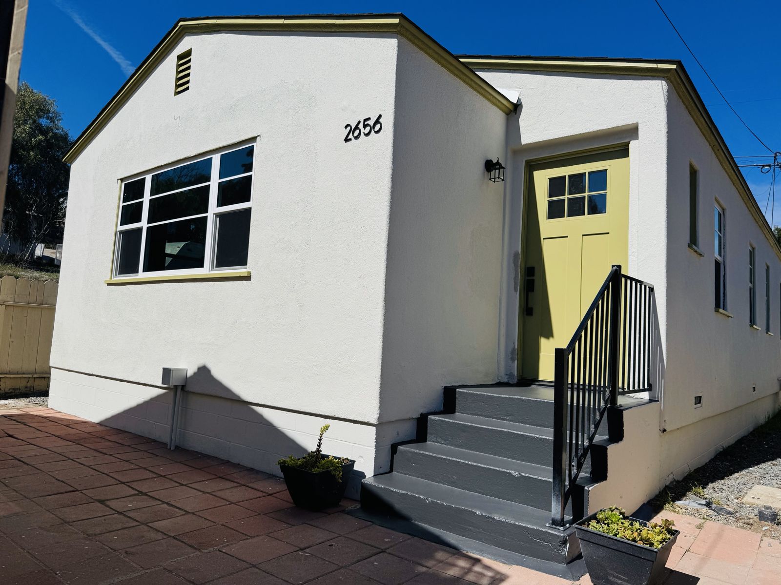 2656 F Street: white stucco home with a yellow front door and new entry stairs
